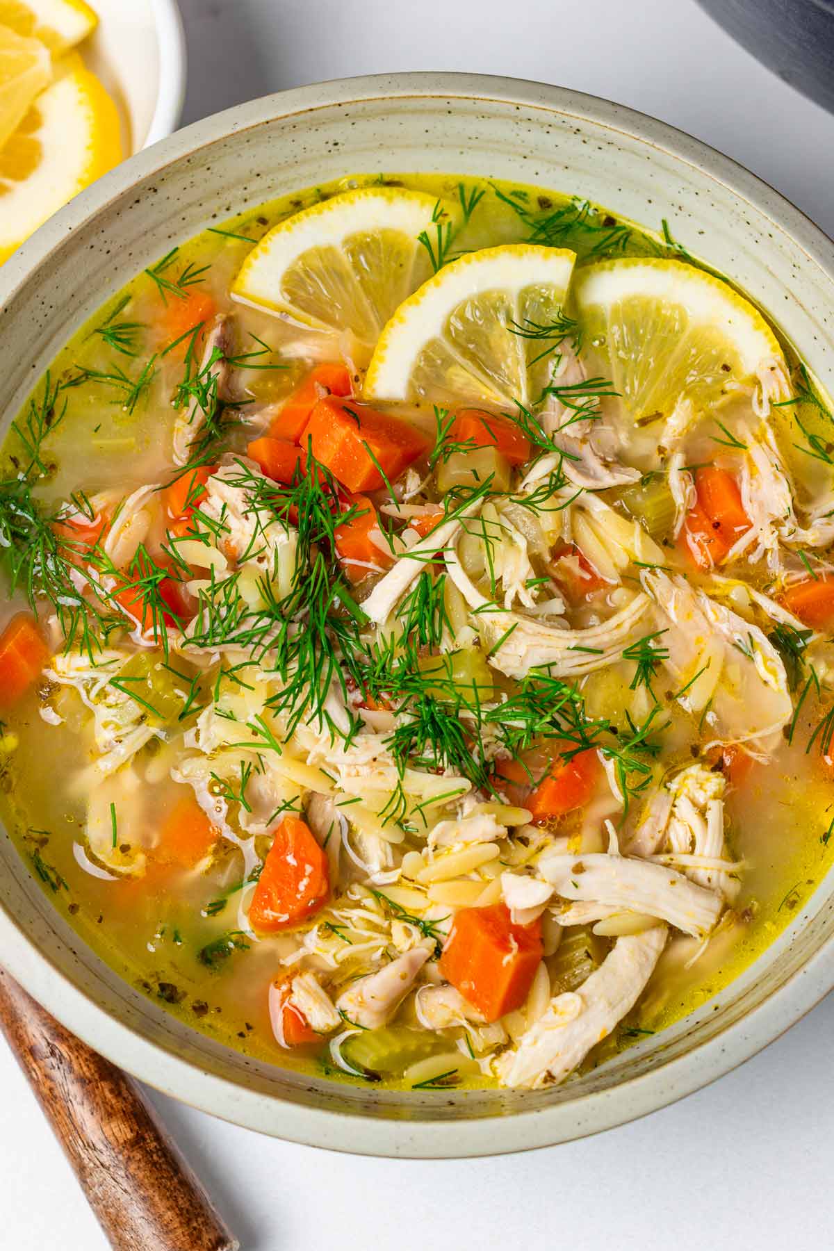 bowl of lemon chicken orzo soup with dill garnish