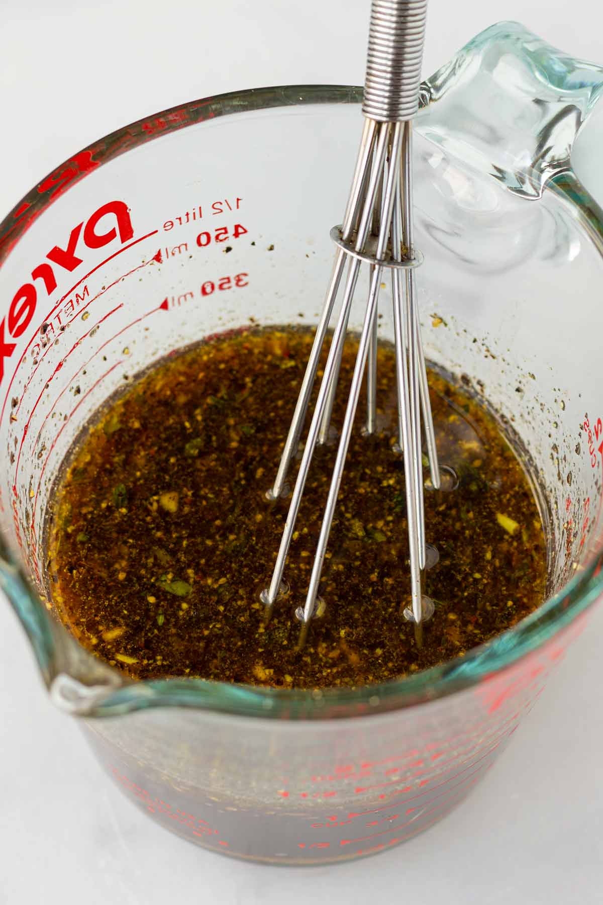 whisking the marinade in a measuring cup