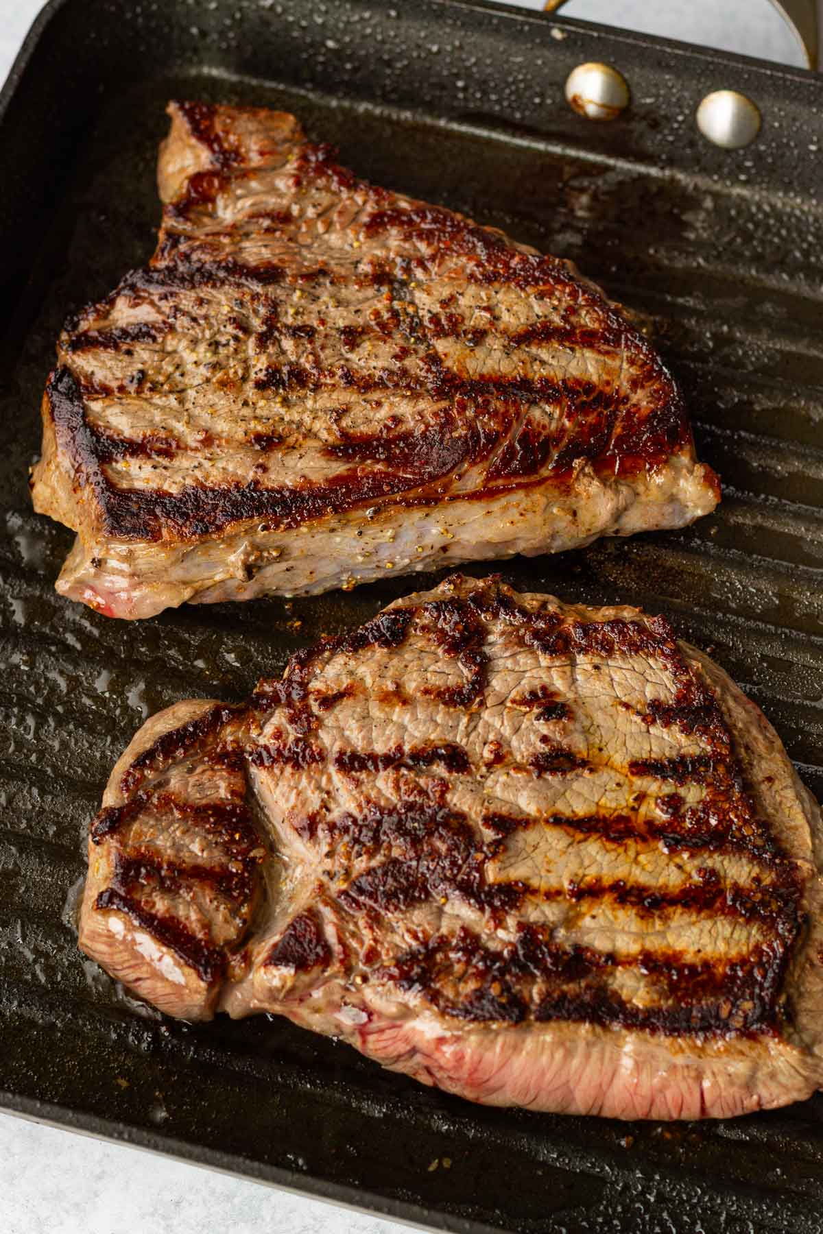cooking seasoned steak on a pan