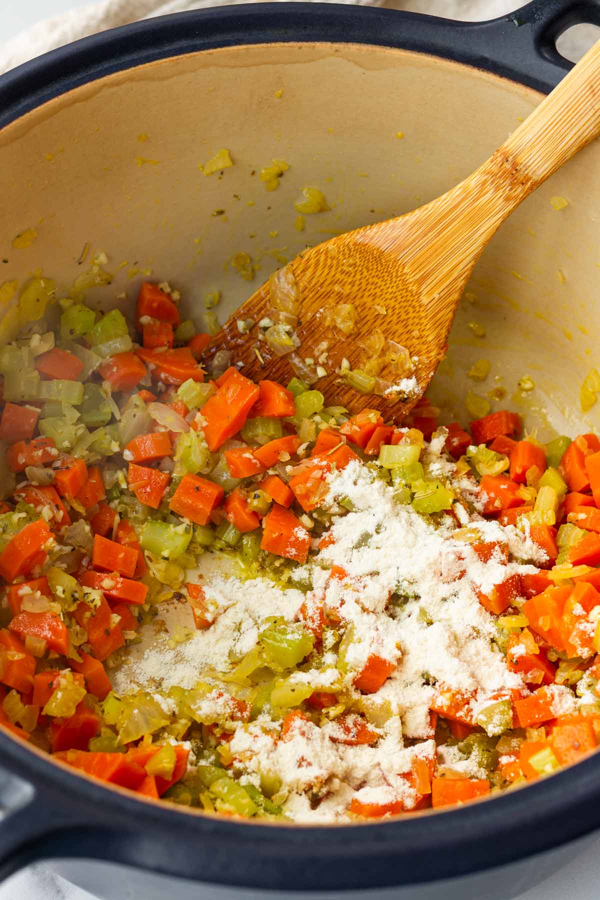 adding flour to the vegetables to coat
