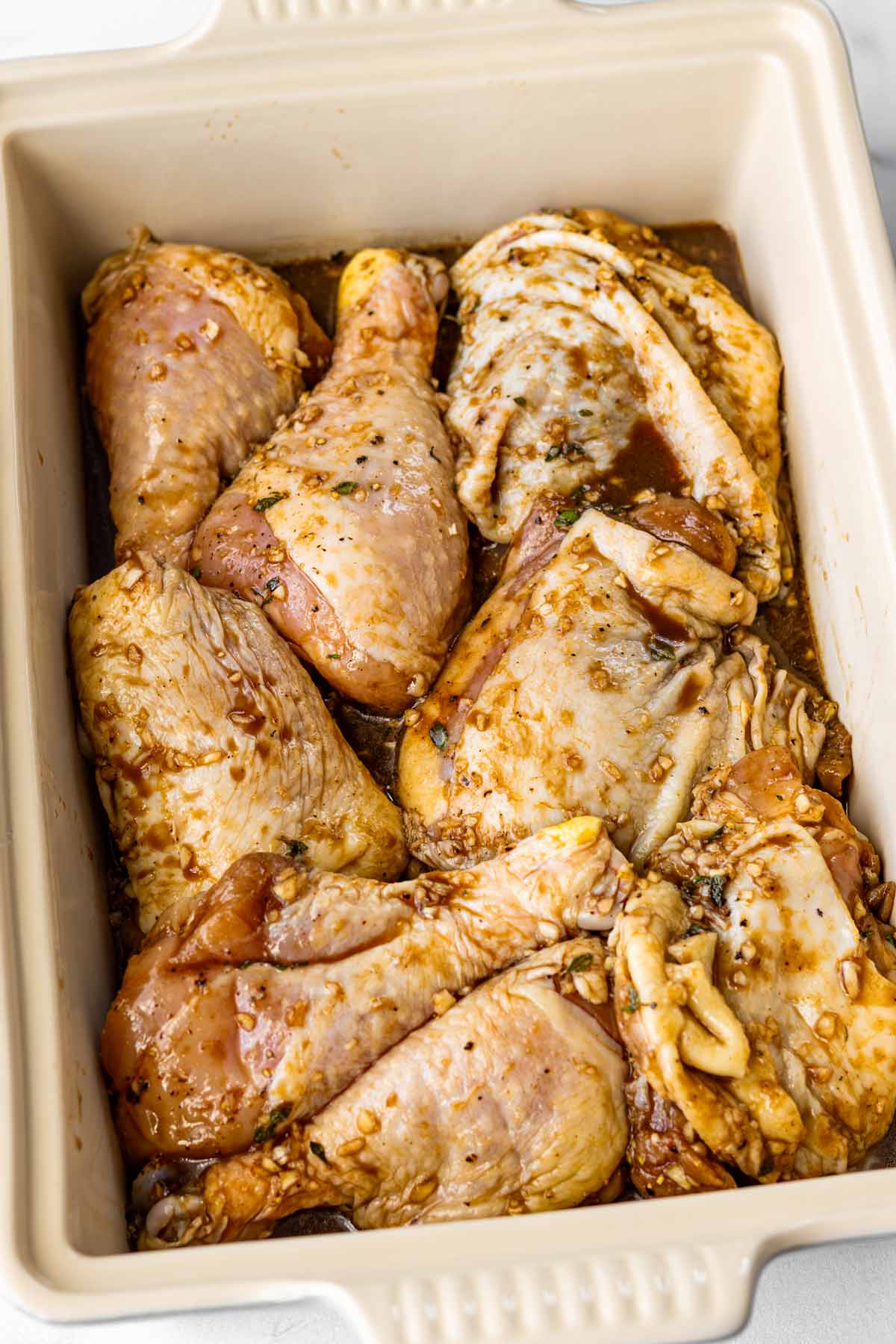 marinated chicken arranged in pan before baking