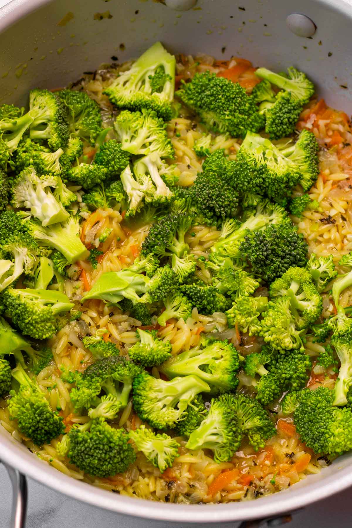 adding broccoli to the pan