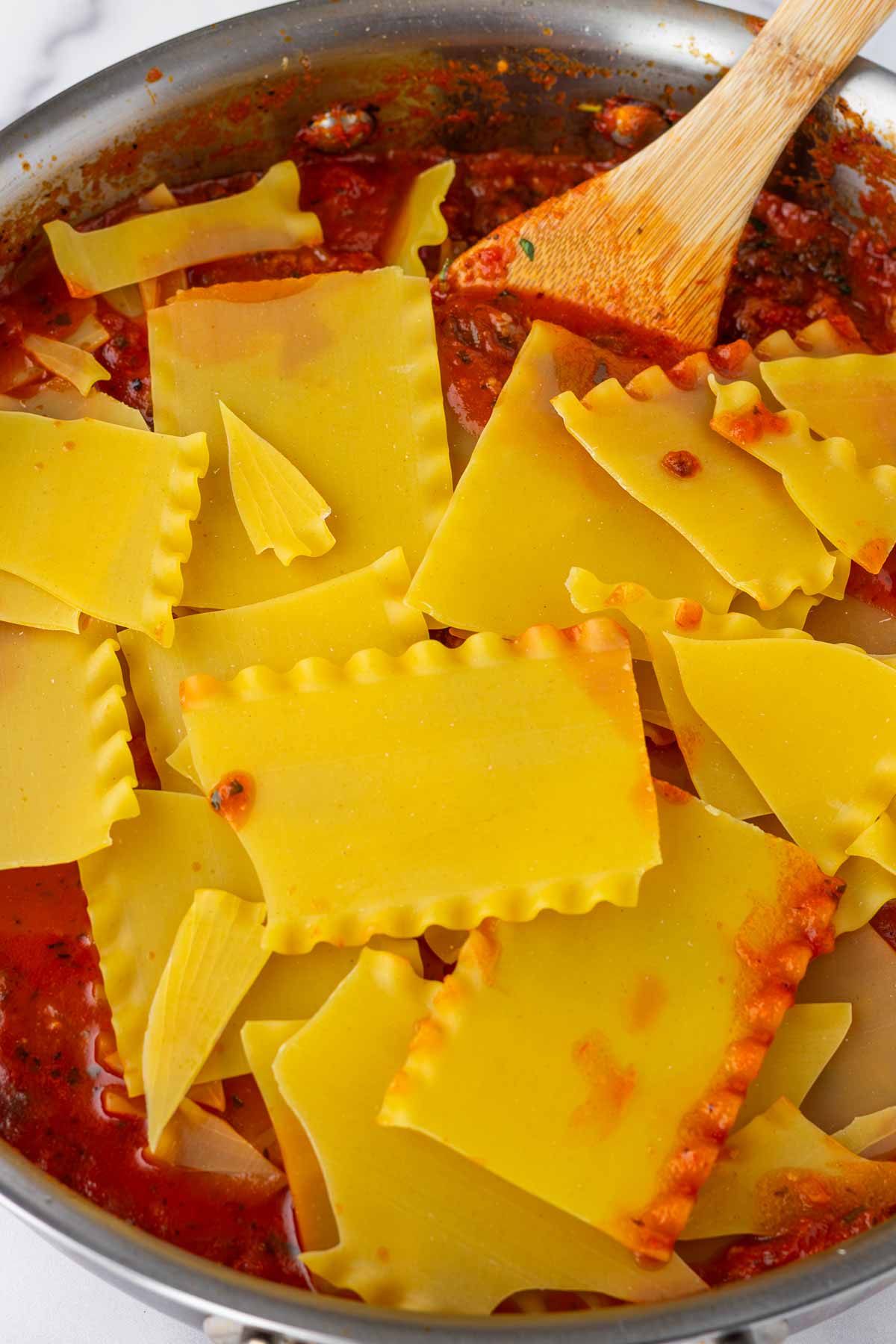 breaking up lasagna noodles into the skillet