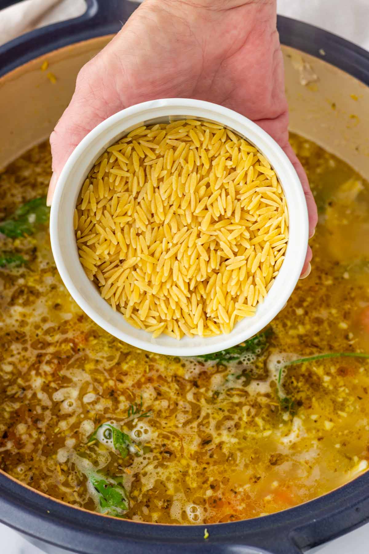 adding orzo to the soup