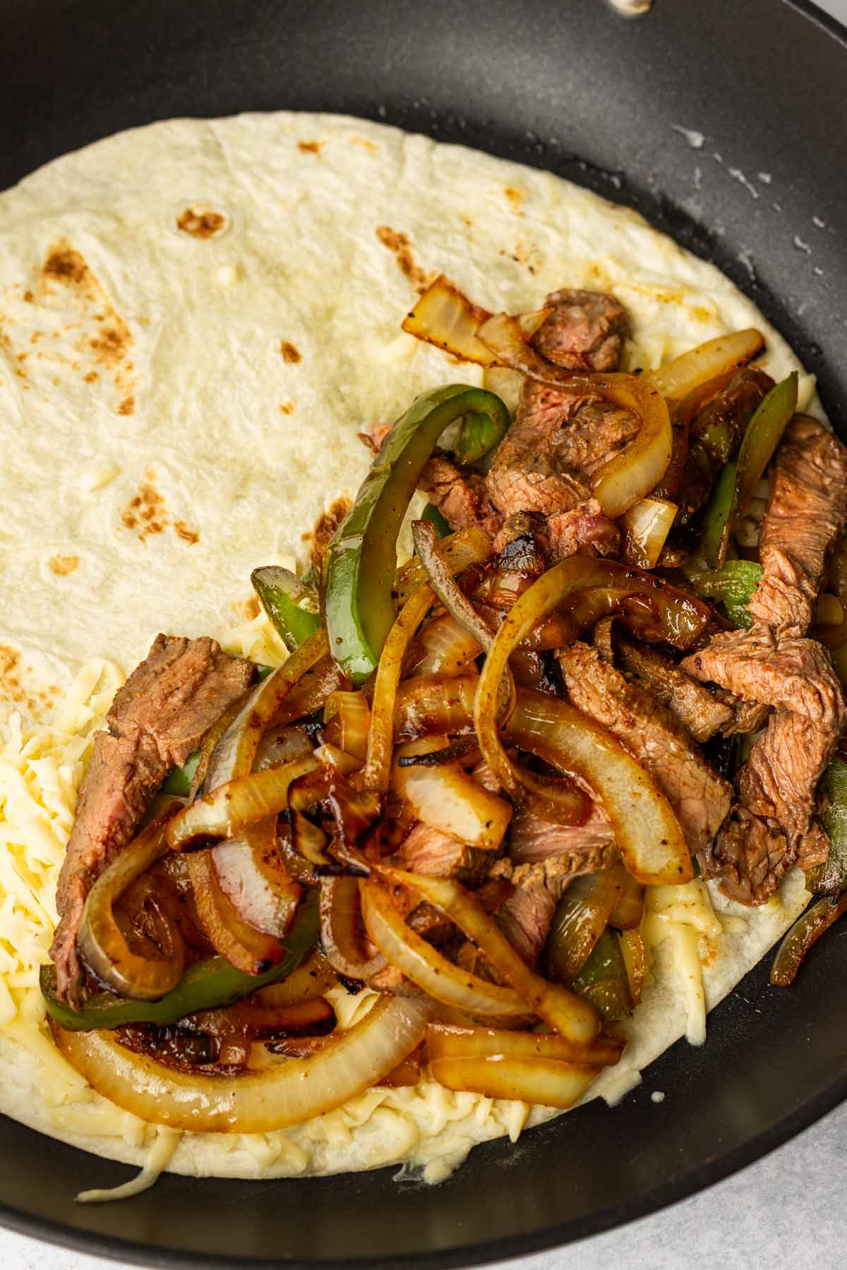 added steak and peppers on top of cheese layer on pan