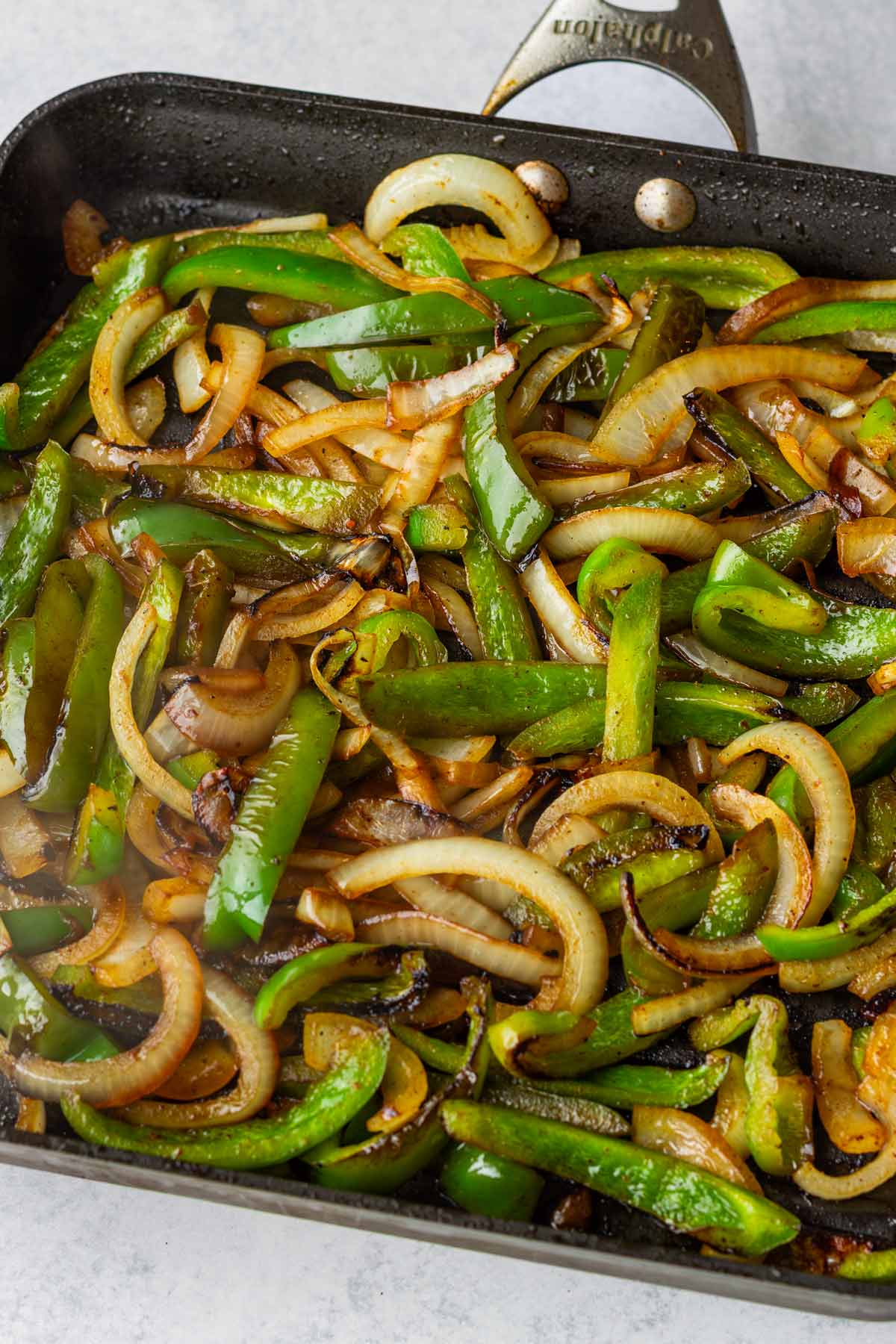 cooking bell peppers and onions in a pan