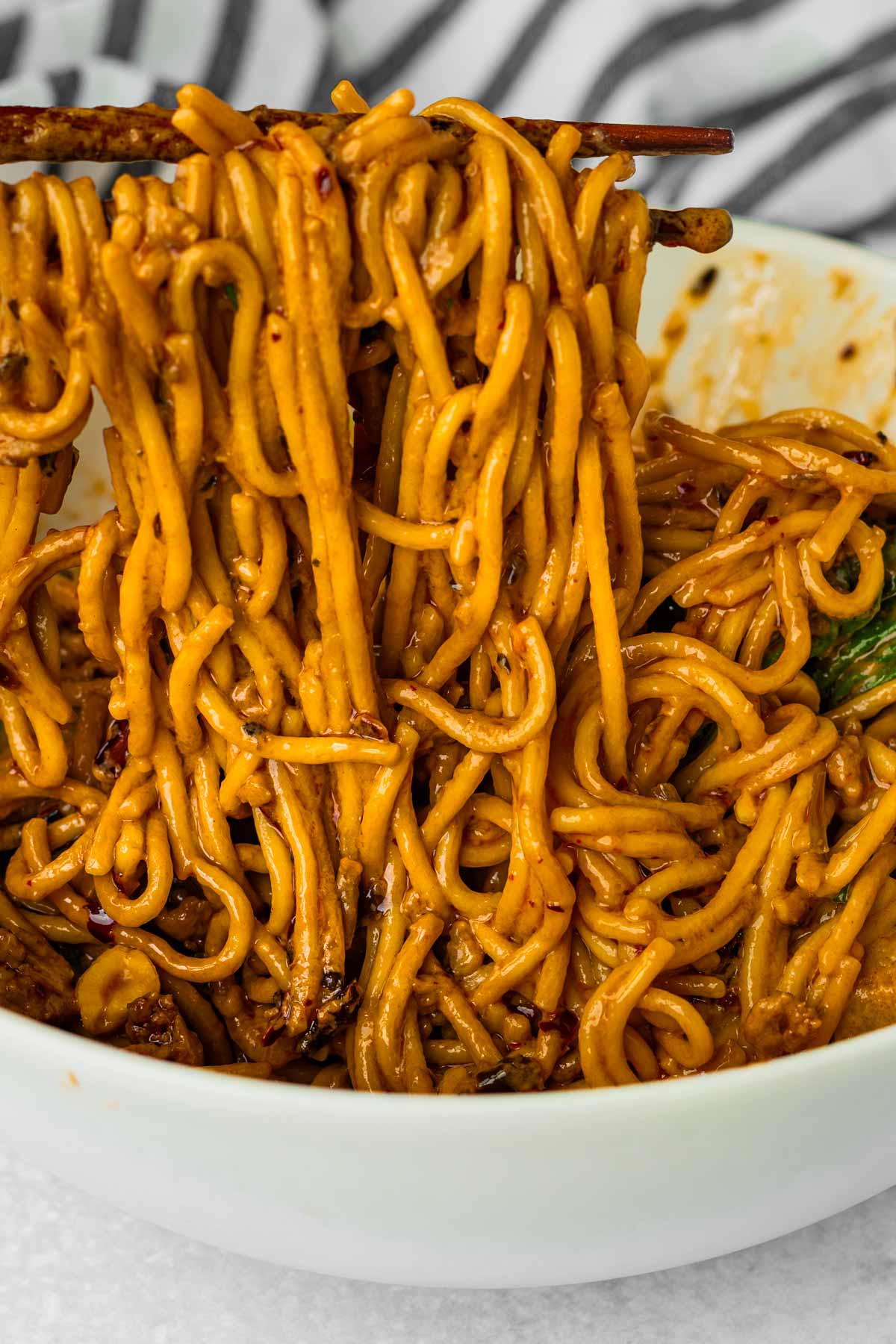 picking up creamy dan dan noodles with chopticks