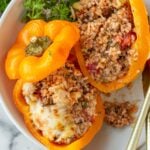 cheesy stuffed peppers with rice and ground beef cut open in half
