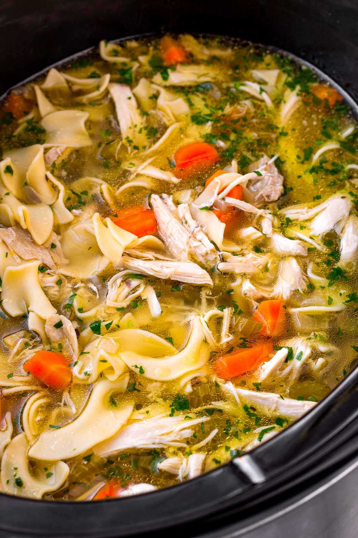 Finished slow cooker chicken noodle soup with shredded chicken