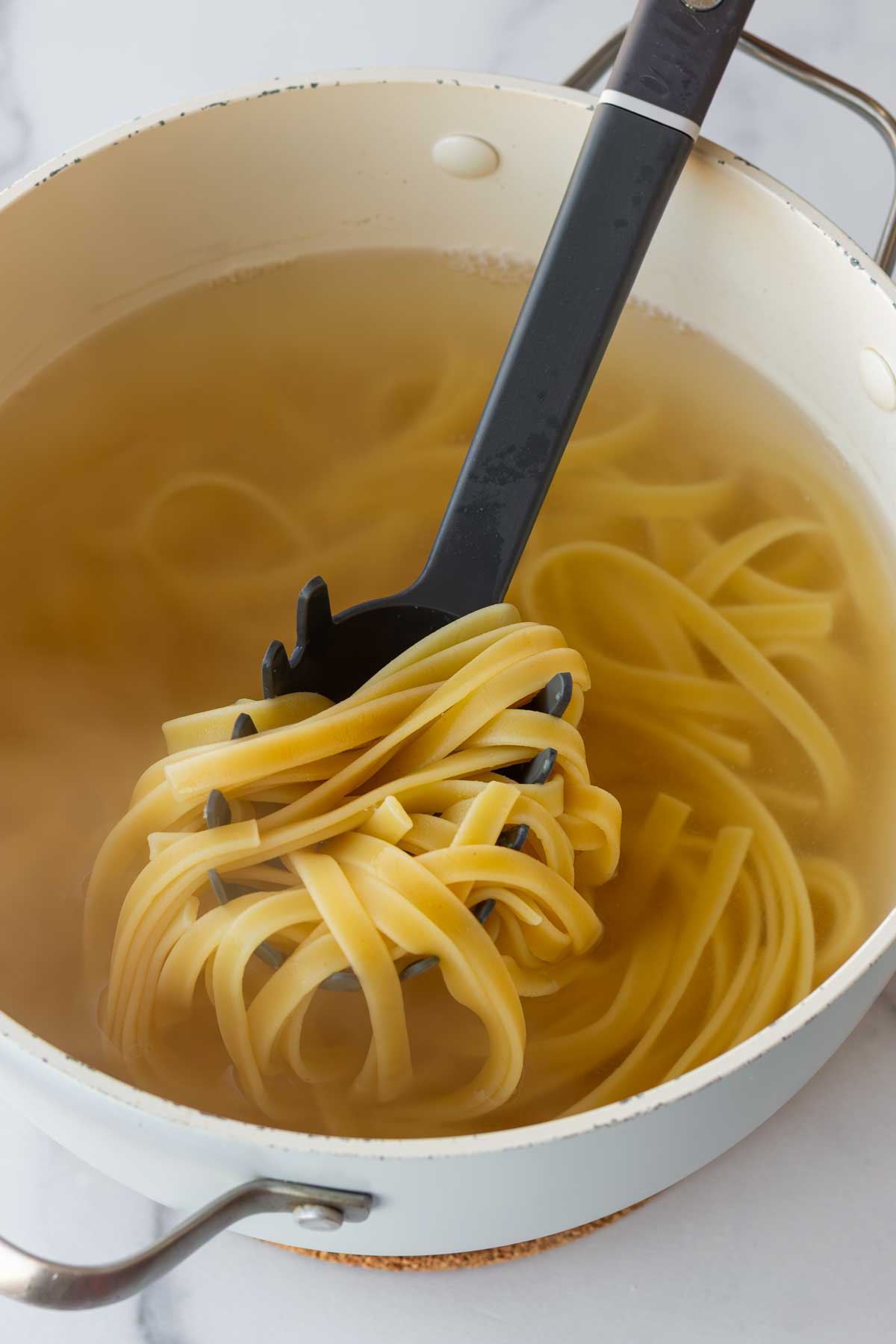 cooking the fettuccine pasta in a pot with water