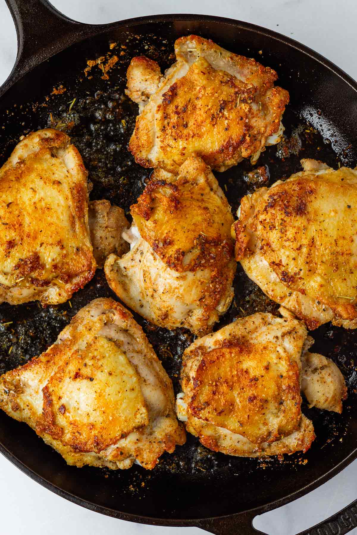 seared bone-in chicken thighs in a cast iron skillet