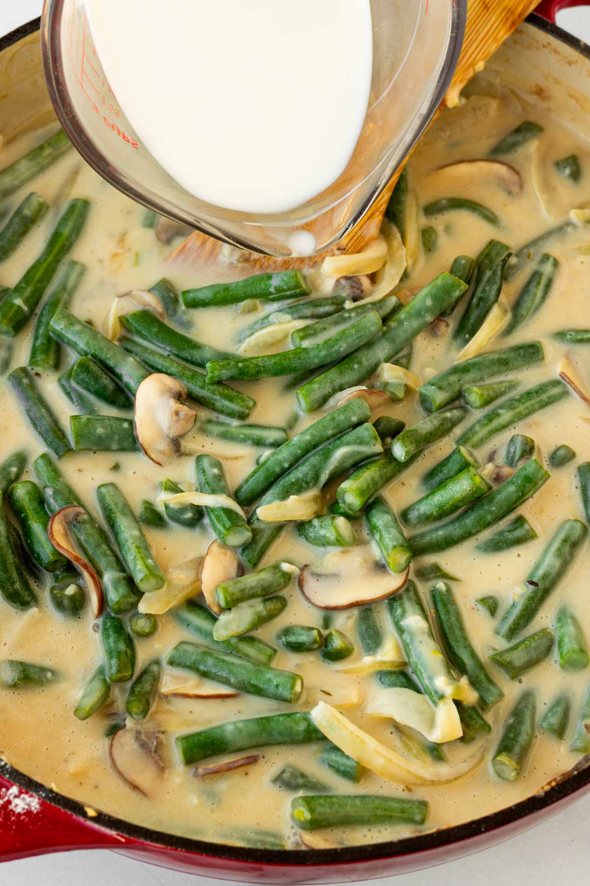 adding broth and milk to the green bean casserole