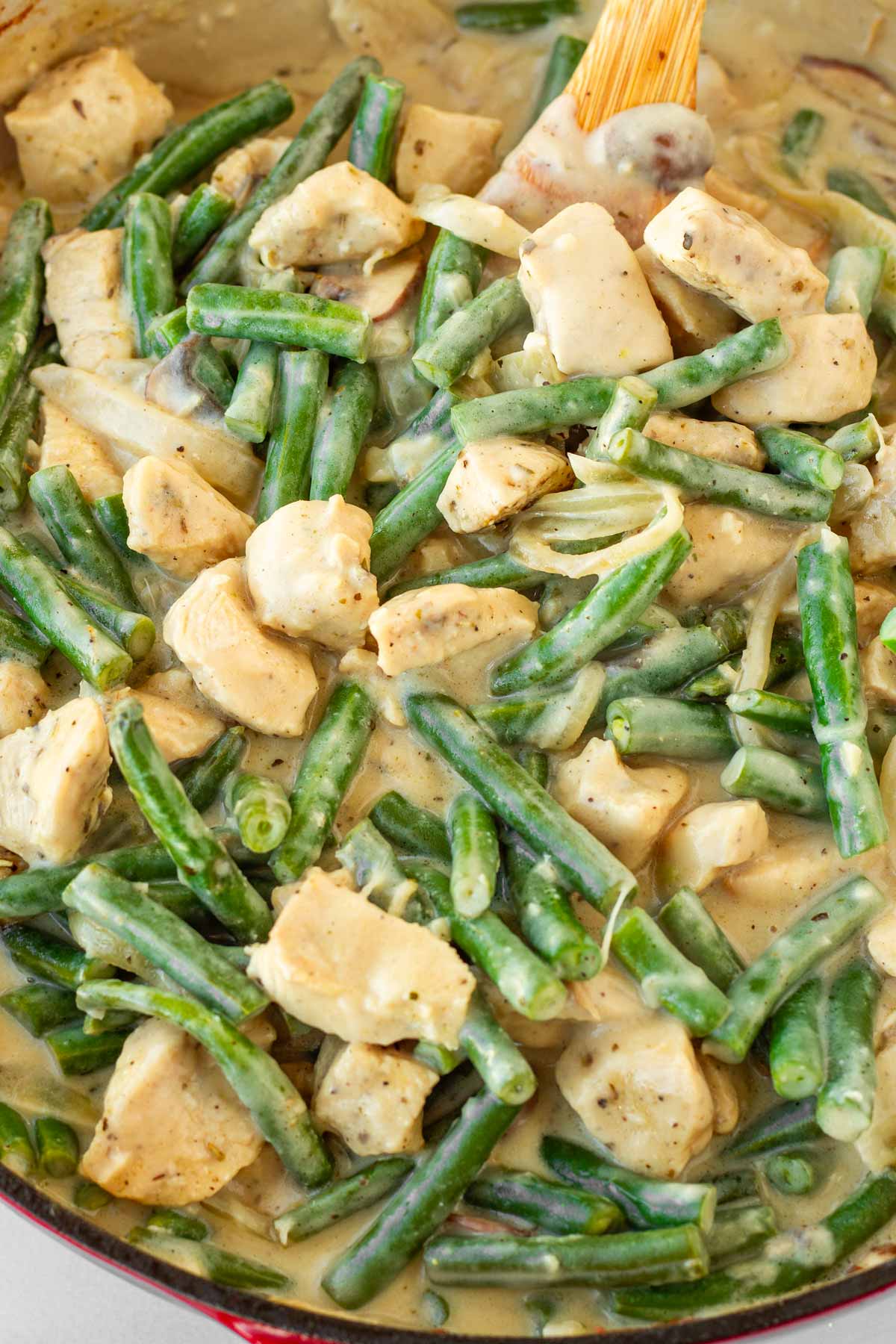 stirring chicken with the green beans and sauce