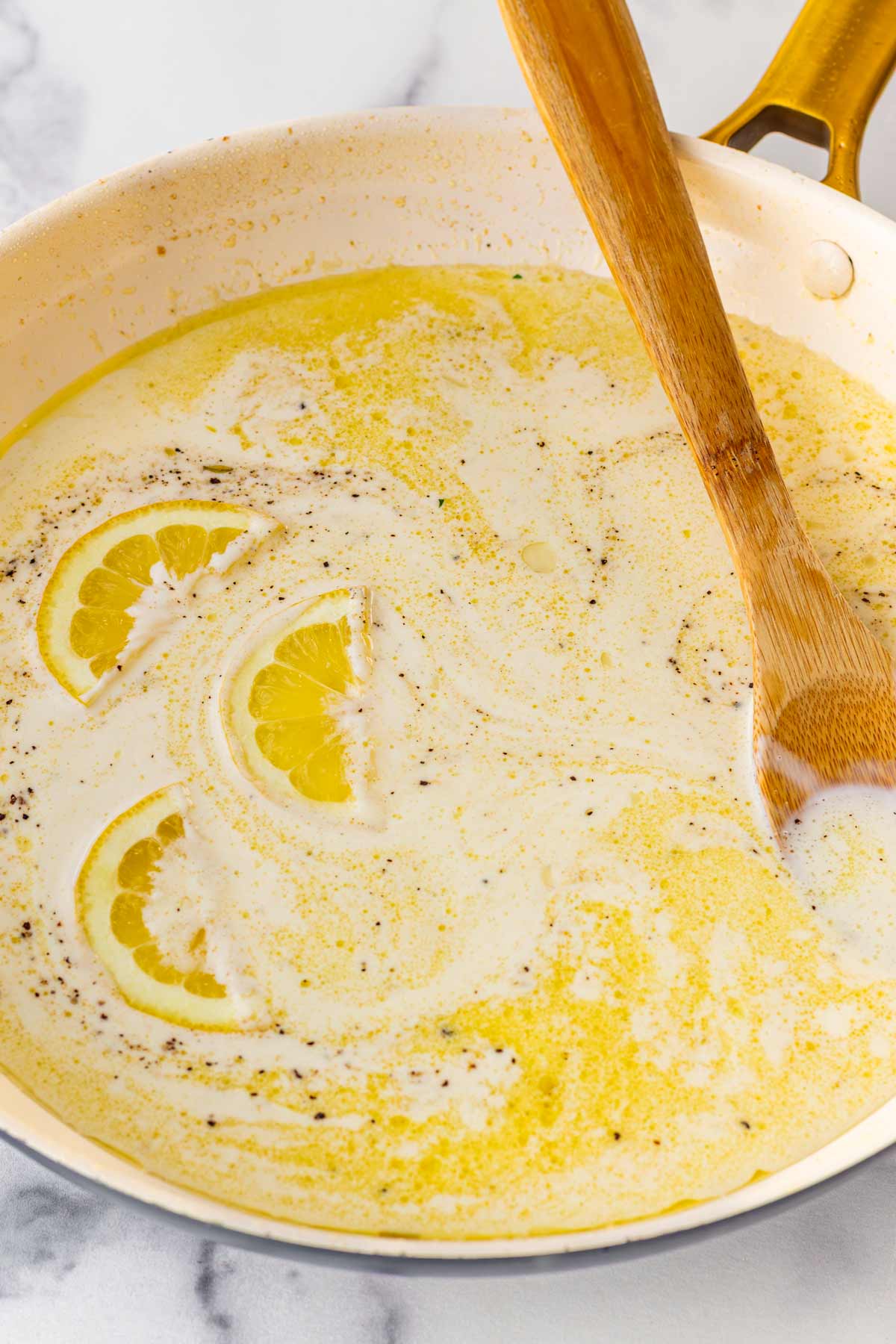 stirring heavy cream and broth into the sauce