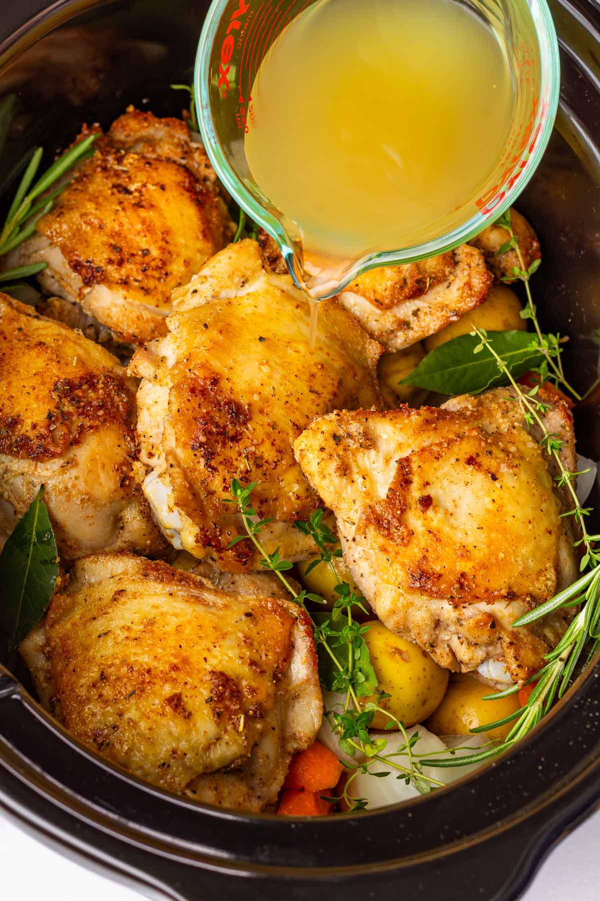 adding chicken broth to the slow cooker