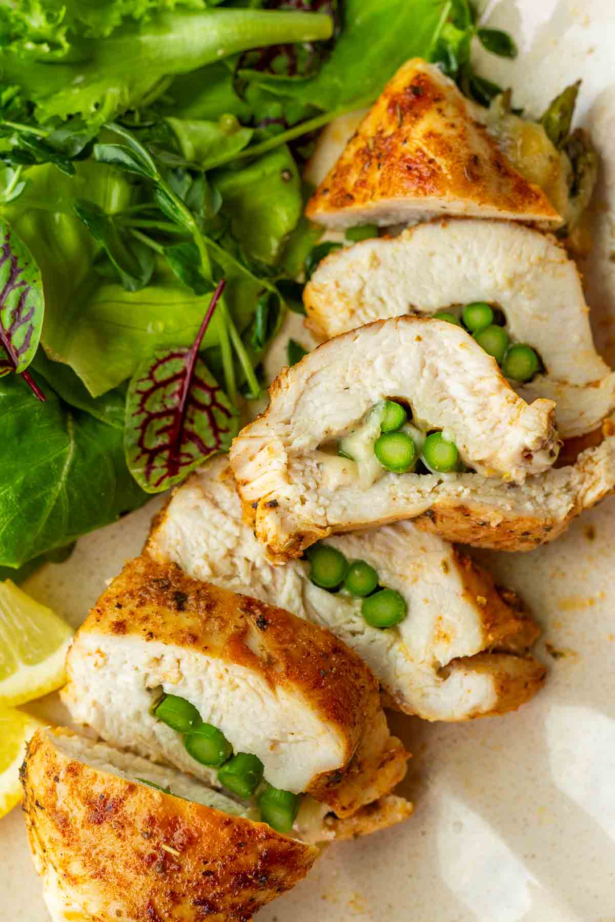 sliced asparagus stuffed chicken breast with side salad