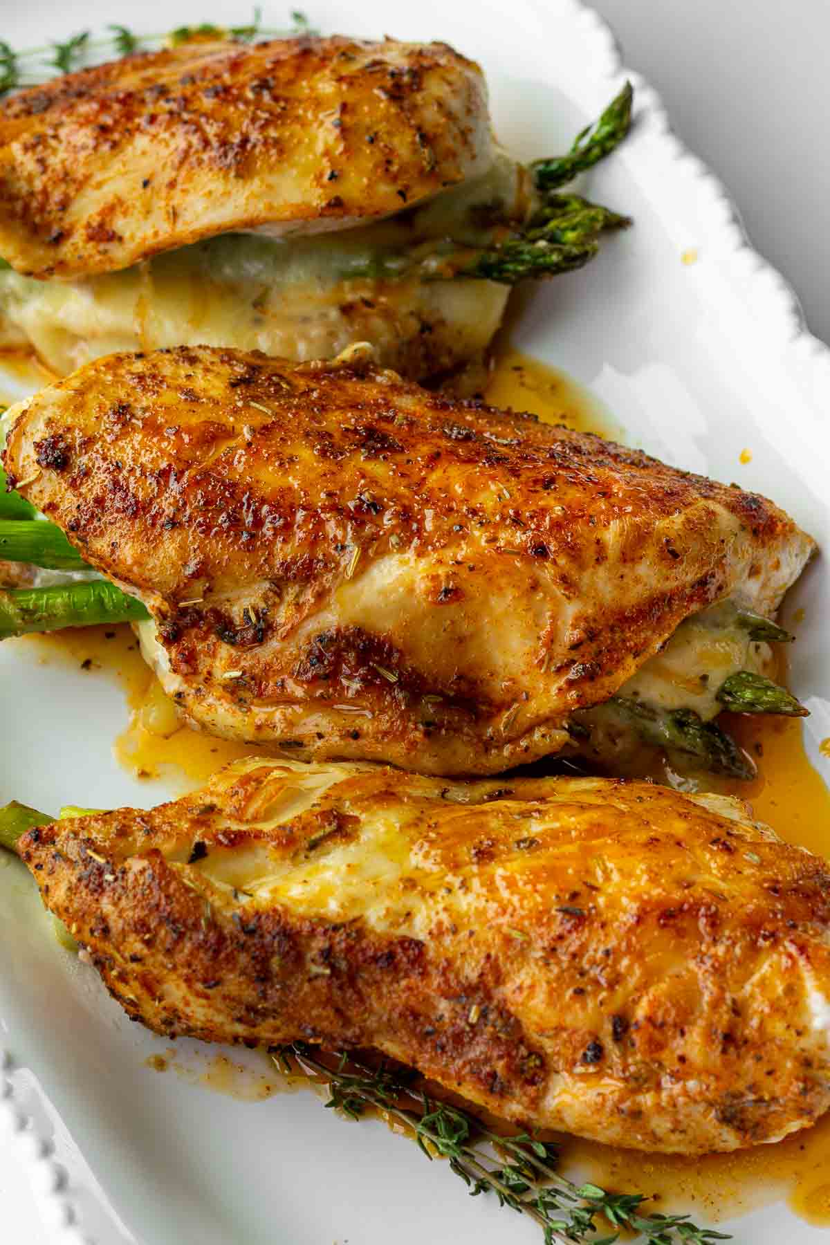 three pieces of stuffed chicken with asparagus on a plate