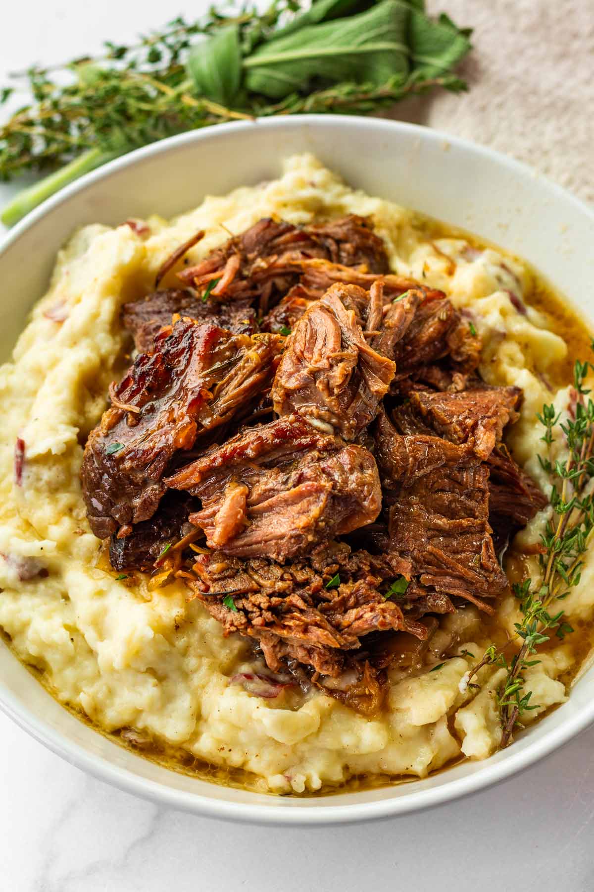 tender fall-apart chuck roast on top of mashed potatoes