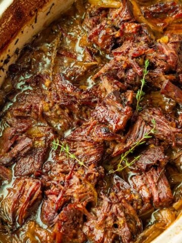 broiled caramelized shredded chuck roast in a baking pan