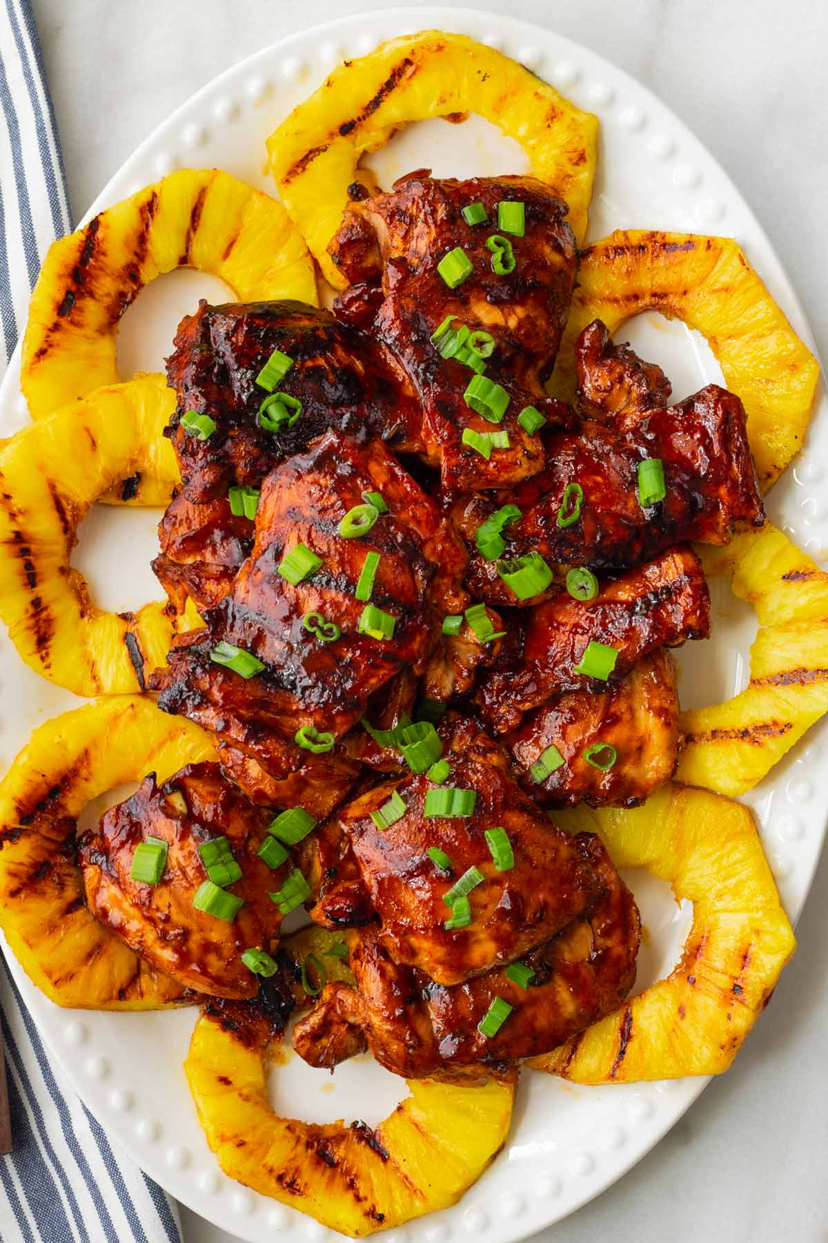 grilled huli huli chicken with grilled pineapple on a round platter