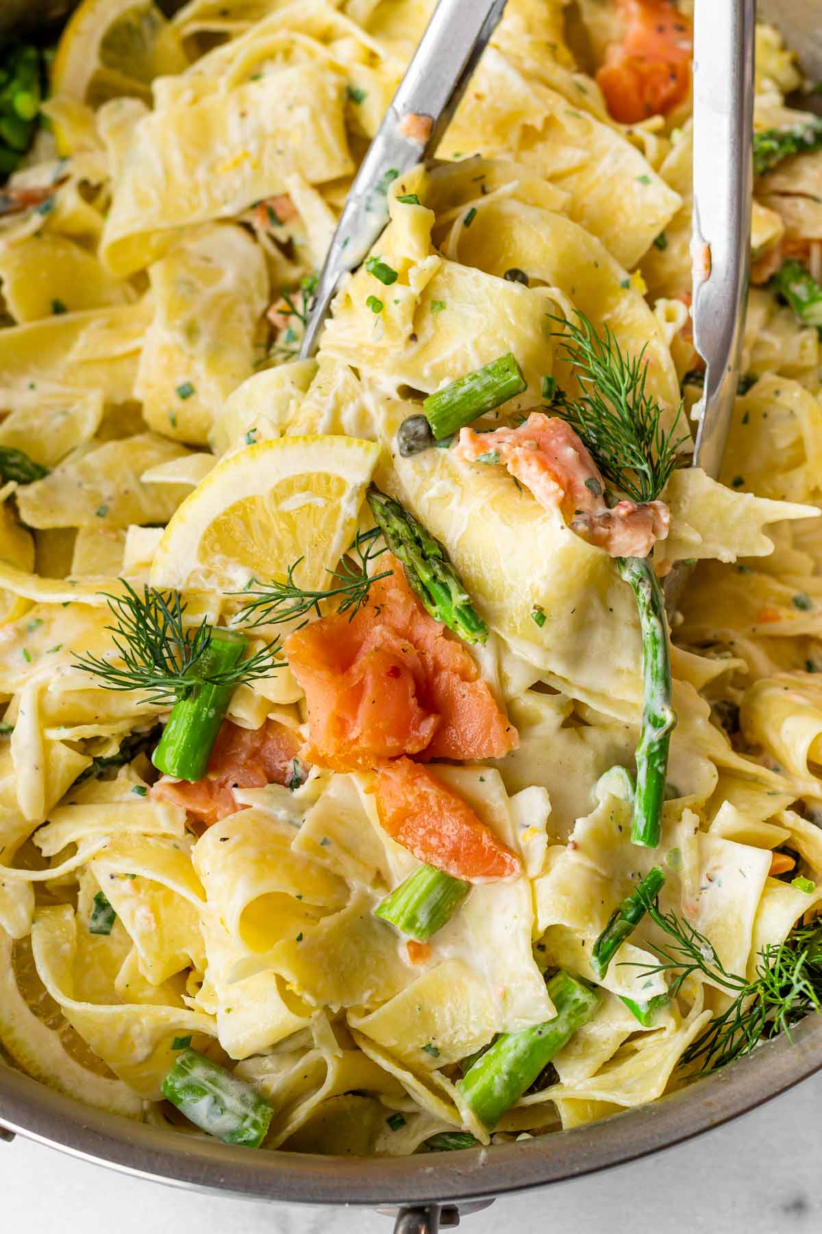 tossing pasta with salmon, asparagus and dill