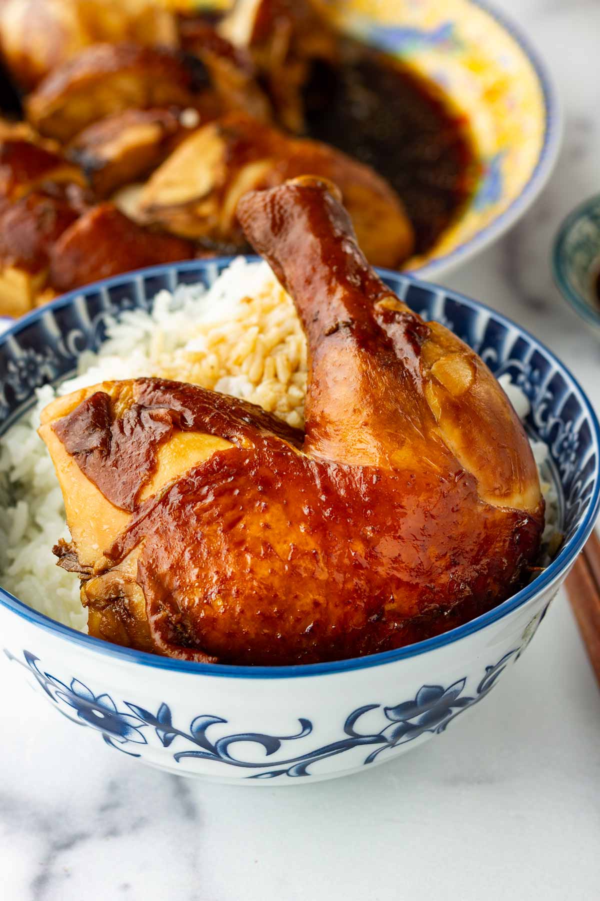 a piece of chinese soy sauce chicken leg on bowl of rice