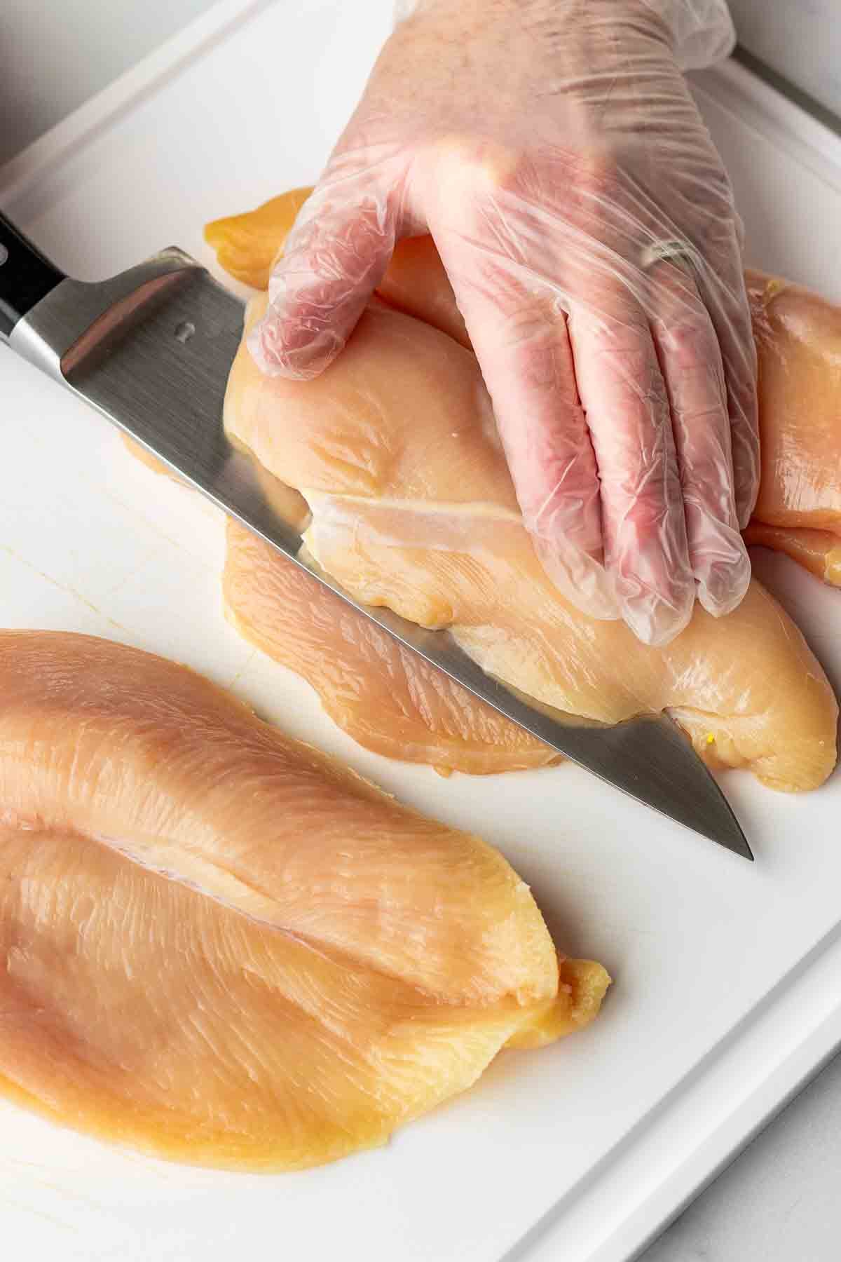 slicing chicken breasts in half to create pockets