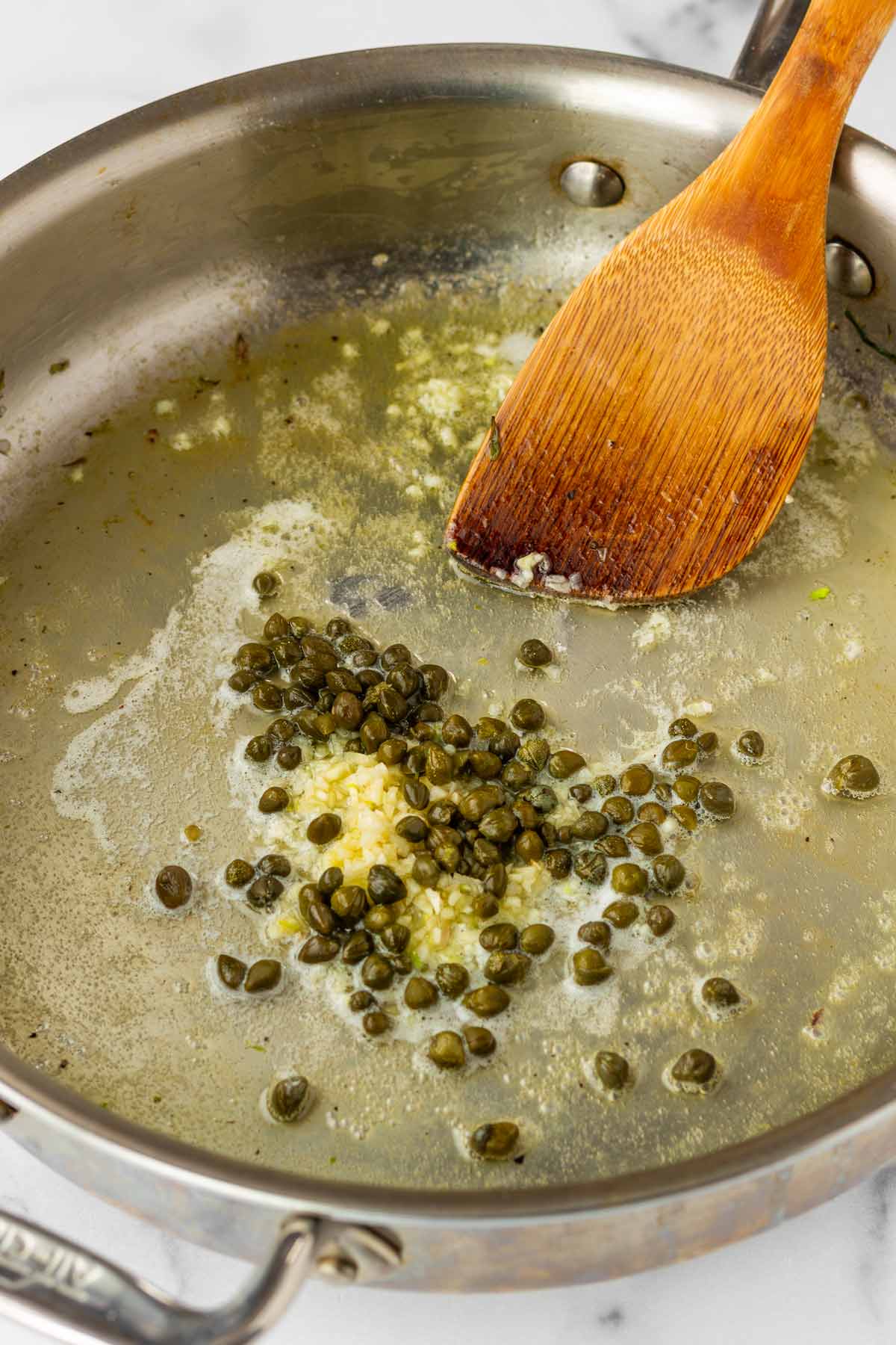 cooking capers and garlic in butter in a skillet
