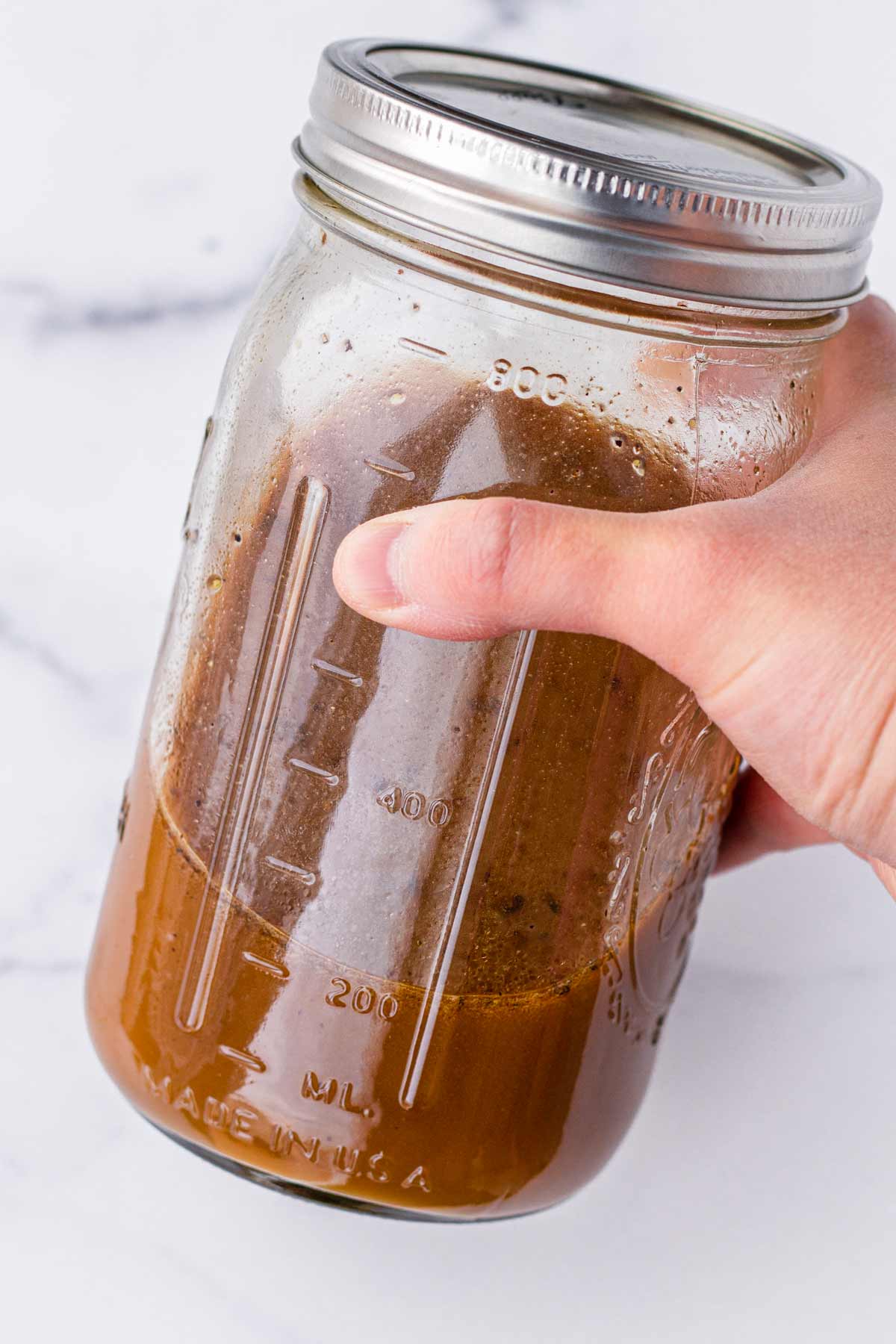 shaking sauce in a sealed mason jar