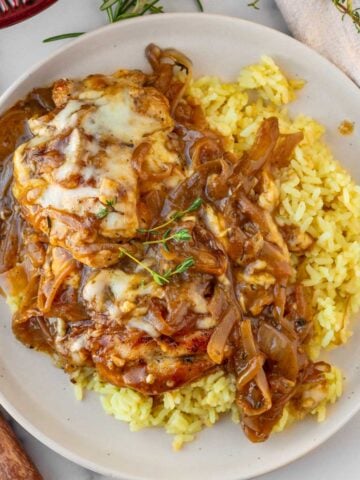 plate of cheesy french onion chicken served on top of rice pilaf
