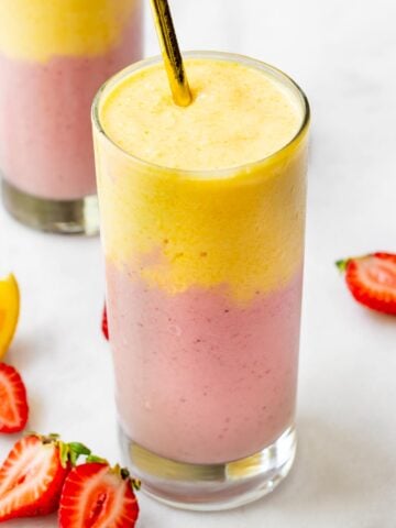 glass of mango strawberry smoothie poured into two layers