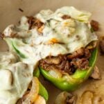 Philly cheesesteak stuffed green bell peppers in pan