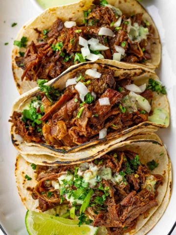 shredded beef tacos piled high with toppings
