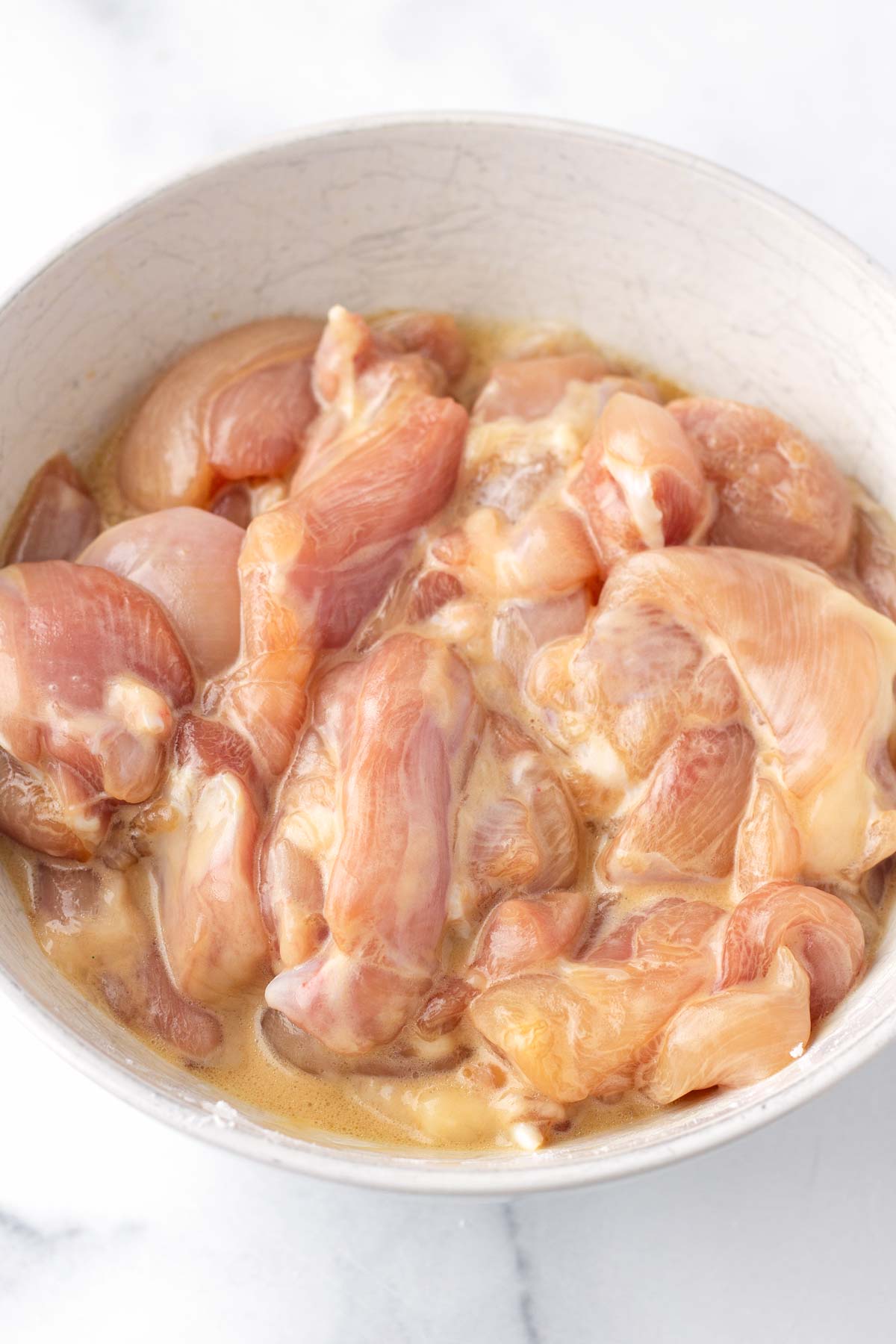 velveting the chicken with baking soda, cornstarch, soy sauce, and shaoxing cooking wine