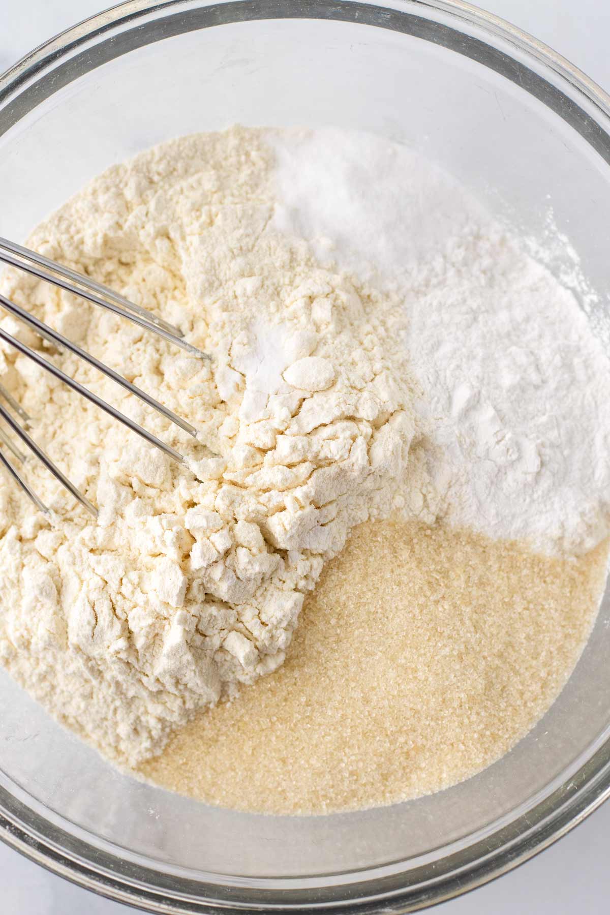 mixing fry ingredients flour, sugar, baking soda, baking powder in bowl