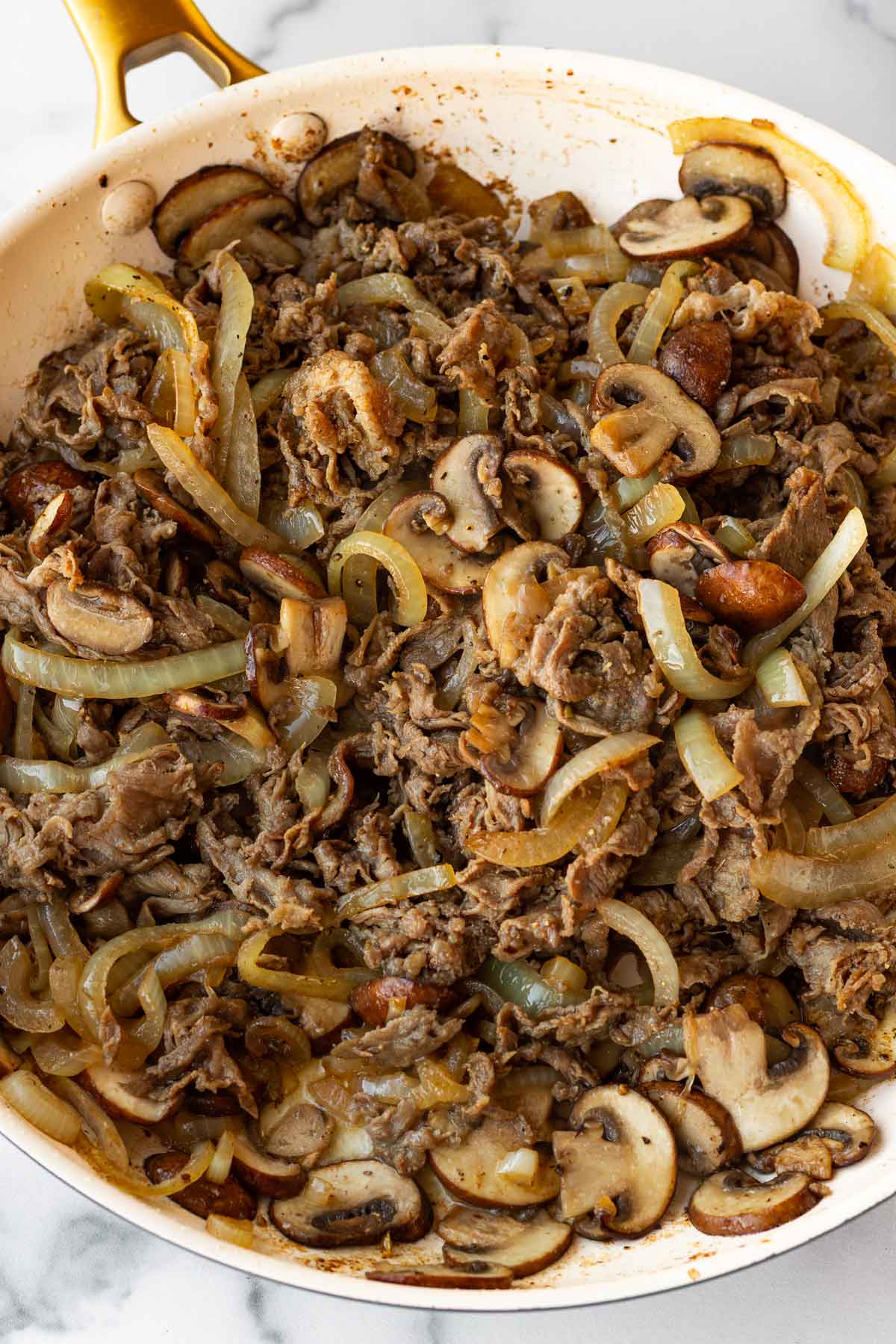 finished cooked cheesesteak filling with steak, mushrooms, and onions
