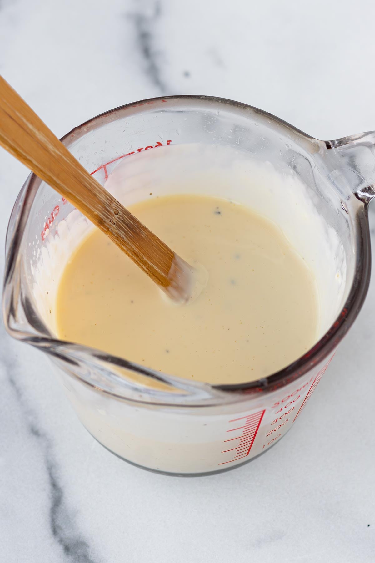 mixing the creamy dressing in a measuring cup