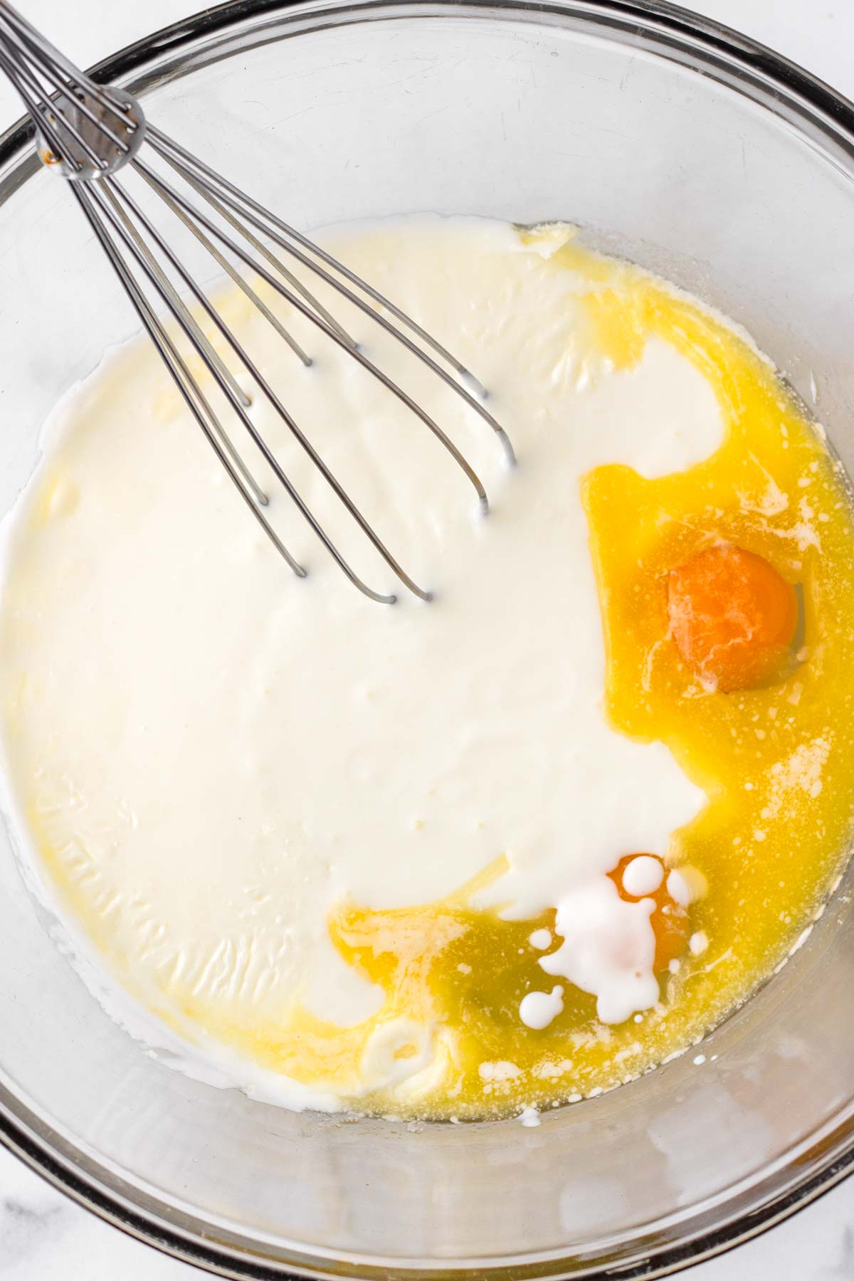 mixing wet ingredients buttermilk, eggs butter in bowl