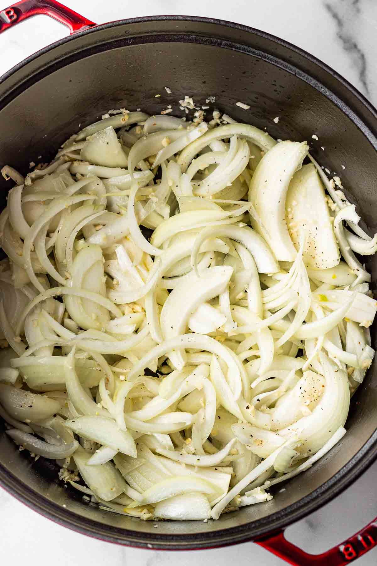 onions, garlic and seasoning in a red dutch oven