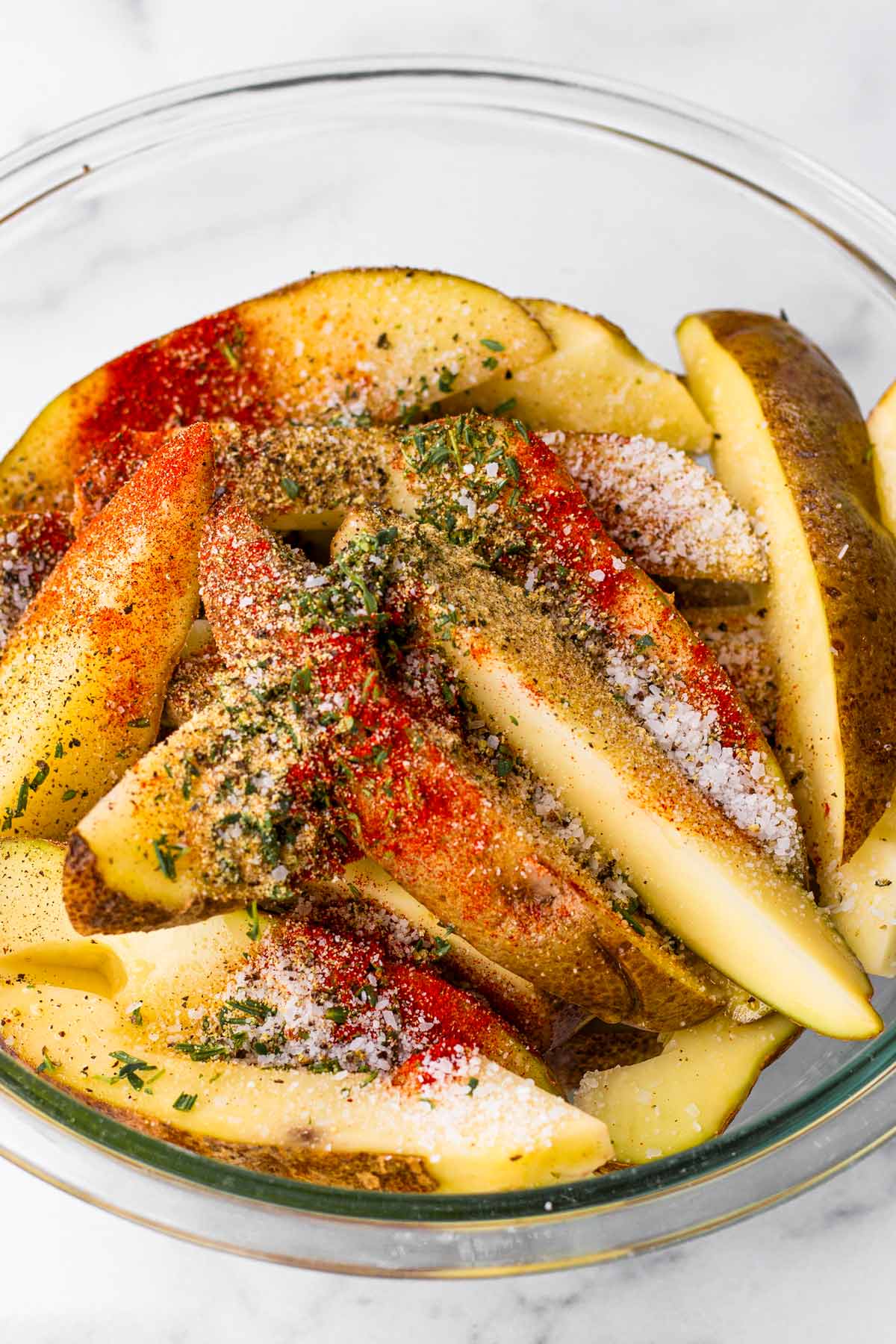 cut up potatoes with seasoning blend in a bowl