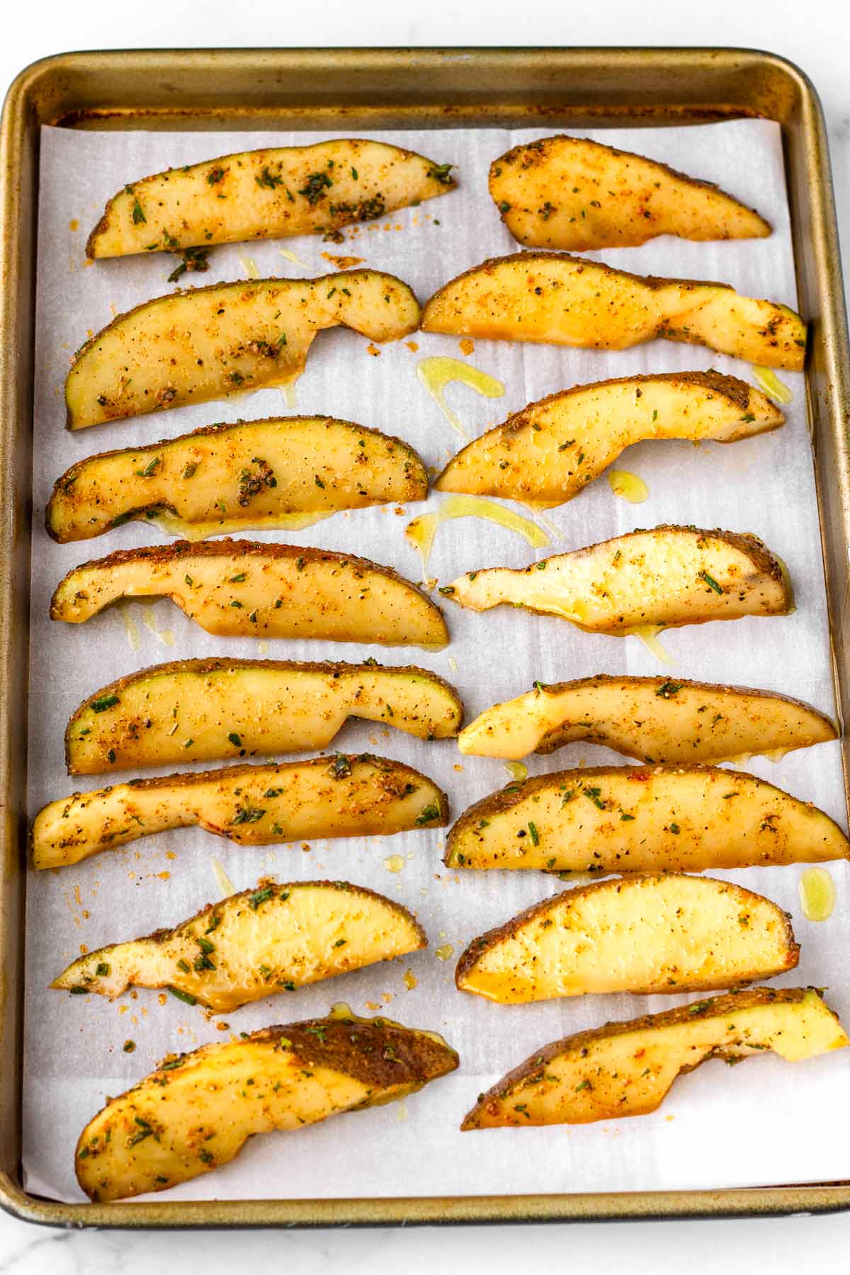 arranged potato wedges on sheet pan lined with parchment paper
