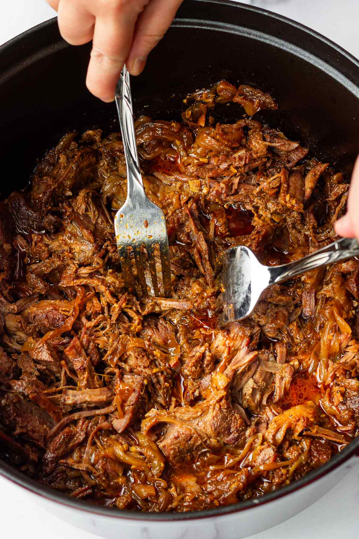 using two forks shred the cooked mexican beef