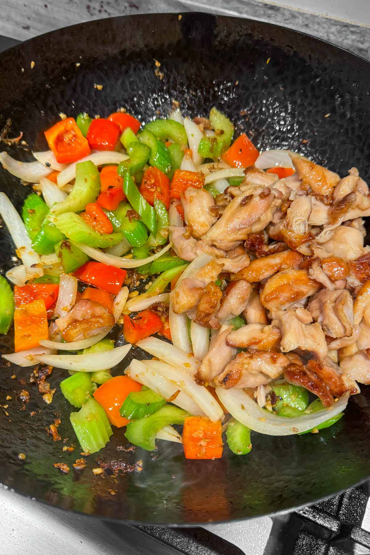chicken added to the wok with the vegetables