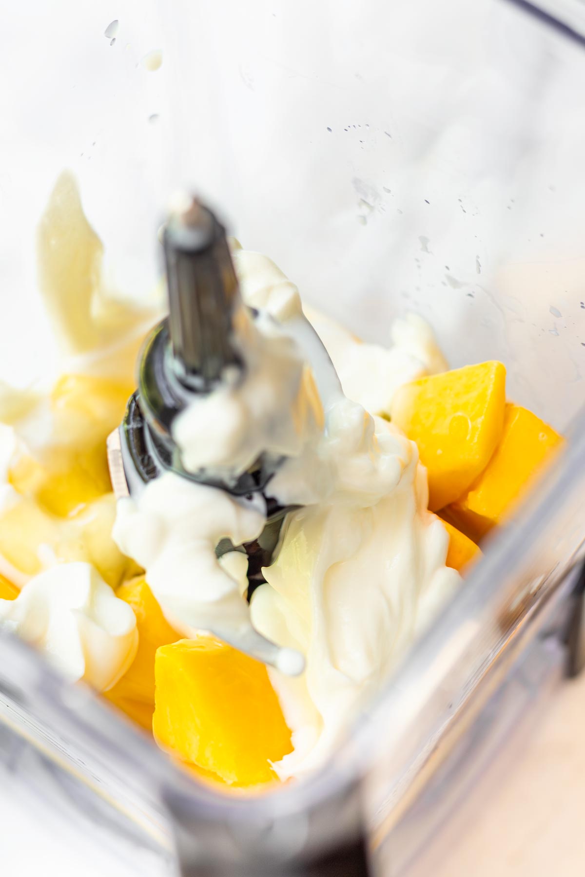 frozen mango chunks, yogurt, milk, juice in blender