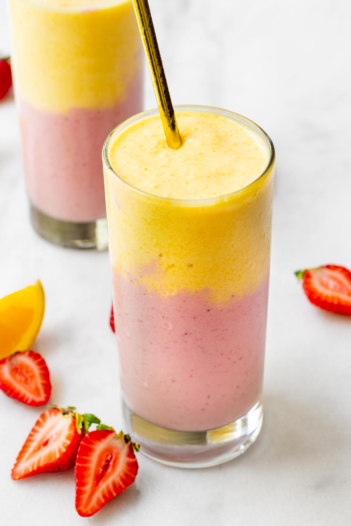 strawberry mango smoothie poured in glass with straw