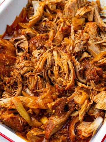 shredded pulled pork cooked in slow cooker in pan