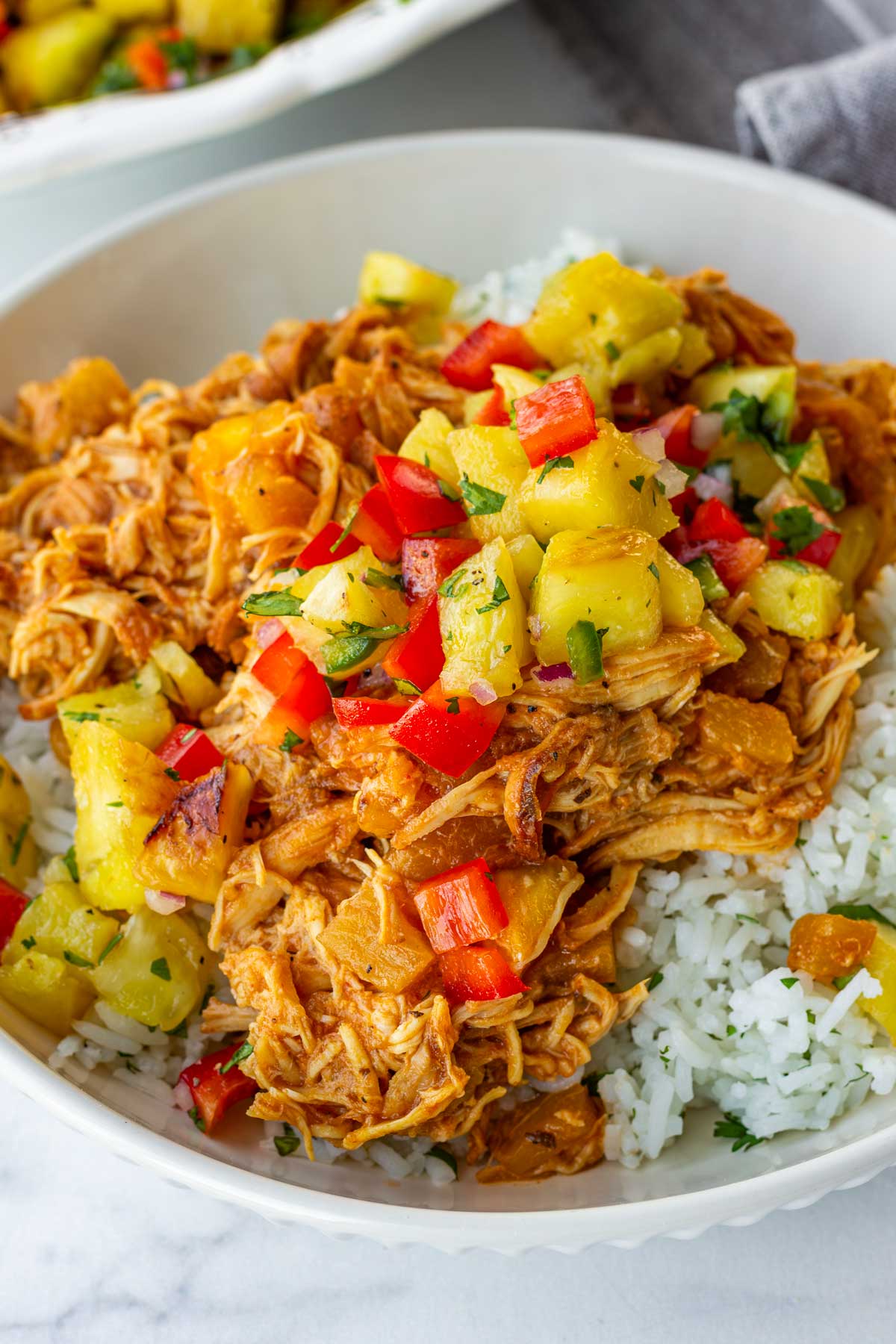 pulled chicken cooked in crockpot over rice and topped with pineapple salsa