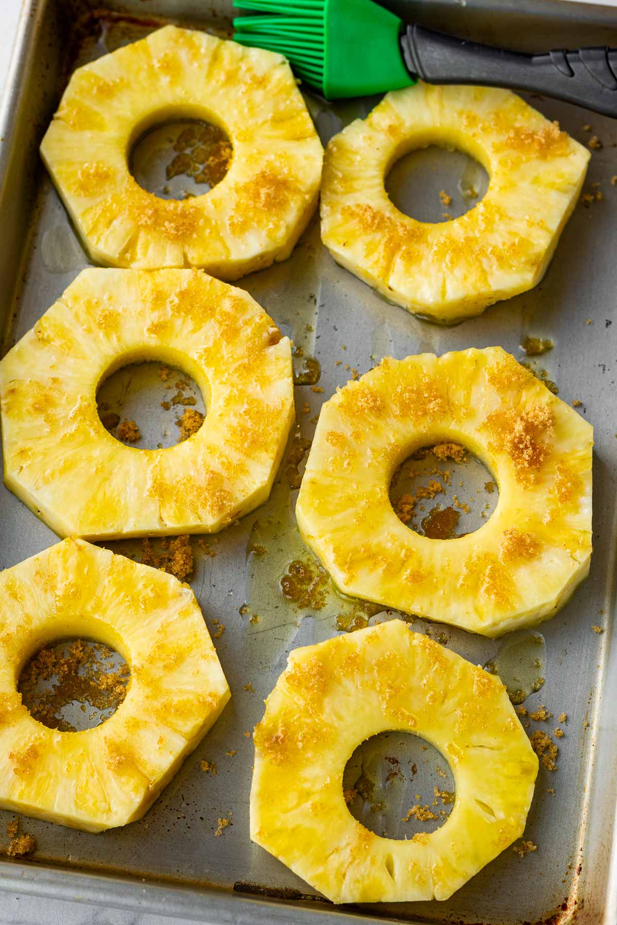 brushing pineapple rings with brown sugar