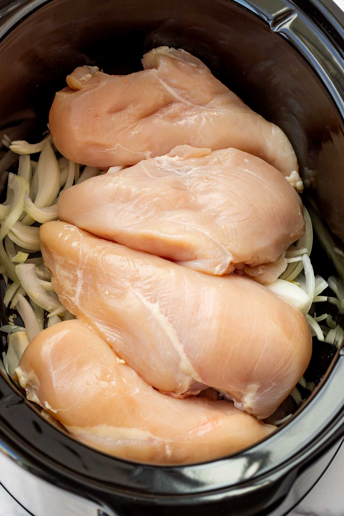 chicken in crockpot over bed of onions