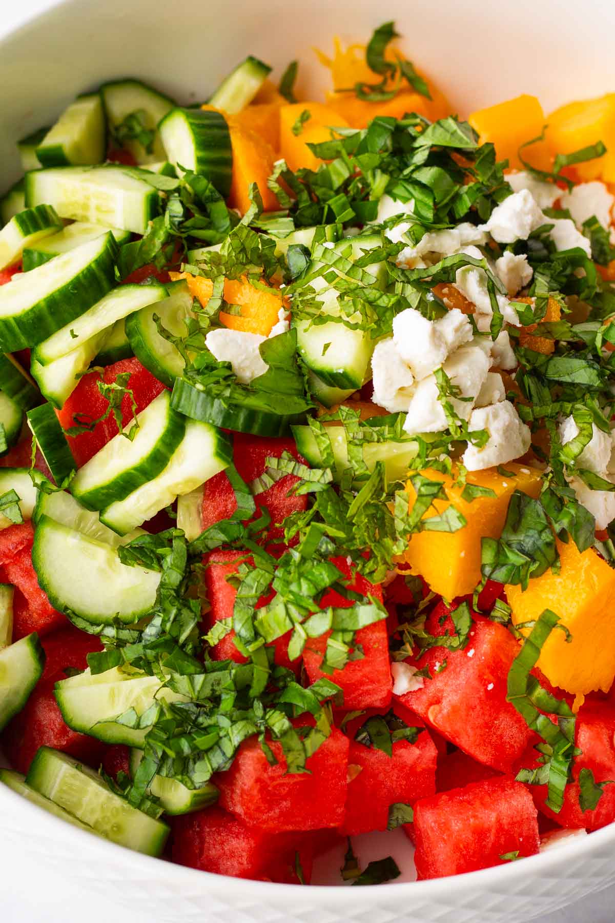 ingredients for watermelon salad added into bowl